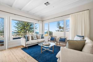 a living room with two couches and a table at Kaya in Collaroy