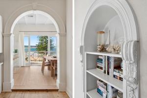 a hallway with an archway and a dining room with a table at Kaya in Collaroy