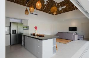 a kitchen and living room with a counter and a couch at Tropik Resort Lombok in Selong Belanak