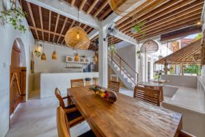 a kitchen and dining room with a wooden table and chairs at Villa Cabala Bali in Canggu