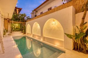 a swimming pool in a house with a building at Villa Cabala Bali in Canggu