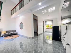 una sala de estar vacía con sofá y TV en Nhà Của Mom, en Buon Ma Thuot