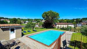 a swimming pool on a deck next to a house at Logis Grand Hotel Pelisson in Nontron