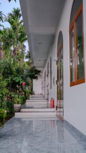 un pasillo de un edificio con escaleras y palmeras en Nhà Của Mom, en Buon Ma Thuot 13 fotos más
