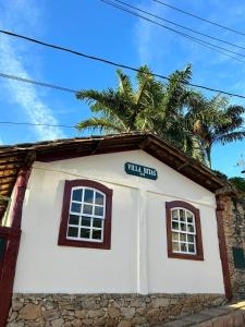 a building with two windows and a sign on it at Hospedagem Casa 46 in Bonfim