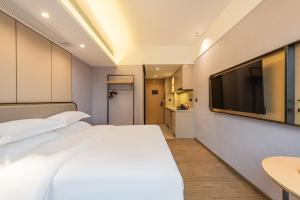 Katil atau katil-katil dalam bilik di Poltton International Apartment - Guangzhou Knowledge City Wangcun Subway Station