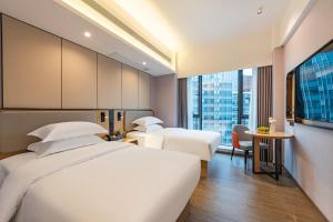 Katil atau katil-katil dalam bilik di Poltton International Apartment - Guangzhou Knowledge City Wangcun Subway Station