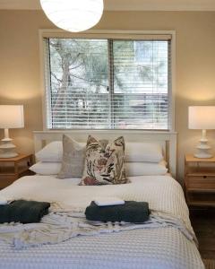 une chambre avec un lit avec des oreillers et une fenêtre dans l'établissement Banksia Retreat, A couple's sanctuary on Aldinga Beach, à Aldinga Beach 17 autres photos