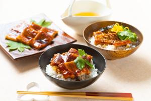 two bowls of food on a table with chopsticks at Vessel Inn Hiroshima Ekimae in Hiroshima