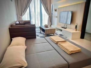 a living room with a large bed and a television at Jk DeLOFTS 03 6Pax 150Mbps 2BedR 2BathR 1Carpark in Kuching