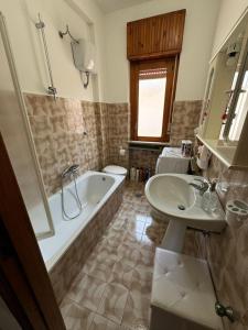 a bathroom with a tub and a toilet and a sink at Appartamento Primavera in Scalea +22 photos