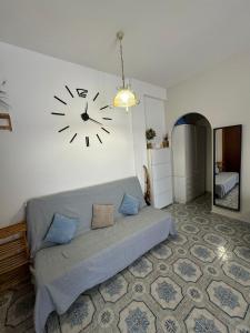 a bedroom with a clock hanging on the wall at Appartamento Primavera in Scalea
