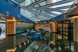 a dining room with tables and chairs in a building at Fabulous Corner Apartment w/ Dazzling Harbour View in Auckland
