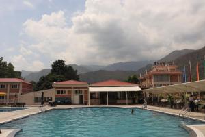 a large swimming pool with mountains in the background at Kwality Beach Resort in Beni Ghāt