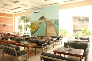 a restaurant with tables and chairs and a mural at Kwality Beach Resort in Beni Ghāt