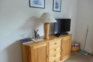 eine Lampe auf einer Kommode mit einem Fernseher in der Unterkunft Ferienwohnung Parkresidenz in Goslar