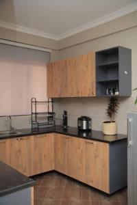 a kitchen with wooden cabinets and a black counter top at Urban Two BR Condo Near Najjera Hospital in Kampala +13 photos