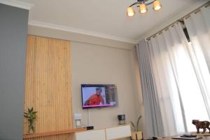 a living room with a tv on a wall at Urban Two BR Condo Near Najjera Hospital in Kampala