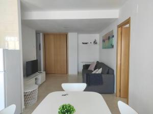 a living room with a couch and a tv at Apartamento Sarastur in Posada de Llanes
