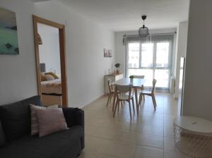 a living room with a couch and a table with chairs at Apartamento Sarastur in Posada de Llanes