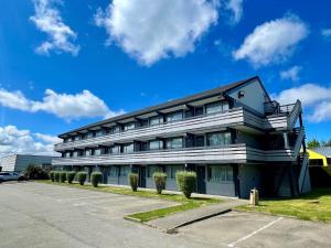 サン・マルタン・デ・シャンにあるBRIT HOTEL Confort MORLAIXの駐車場付きの大きな建物