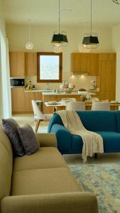 a living room with a blue couch and a kitchen at Wateera Jebel Sifah in As Sīfah