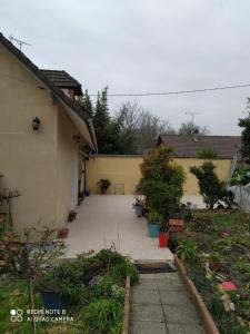 a backyard of a house with a courtyard with plants at GITE Chez Marilou in Aulnay-sous-Bois