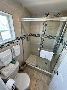 a bathroom with a shower and a toilet at Sunset Beach Hotel in Wildwood +38 photos
