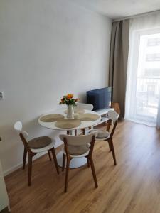 a table and chairs with a vase of flowers on it at Prechodná stanica in Brezno +5 photos