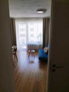 a living room with a blue couch and a window at Prechodná stanica in Brezno
