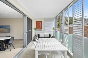 Un comedor con mesa y sillas y ventanas. en Vibe at Newport, en Newport
