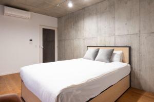 東京にあるLEGALAND Sangenjaya ANNEXのコンクリートの壁のベッドルーム1室(大きな白いベッド1台付) +59枚の写真