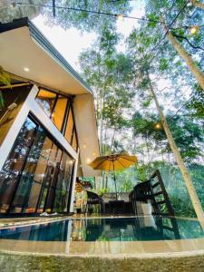 a house with a swimming pool and an umbrella at La Cabaña - Private Cabin in Quelalag