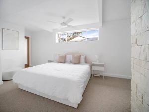 a white bedroom with a white bed and a window at Luxury Home in the Vale in Berkeley Vale +29 photos