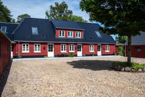 a red house with a black roof at Lejlighed B in Vejle