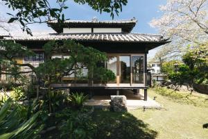 uma pequena casa com um banco num jardim em PAAK Hotel em Nichinan