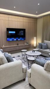 a living room with two couches and a flat screen tv at شقة فاخرة قرب الحرم النبوي in Al Madinah