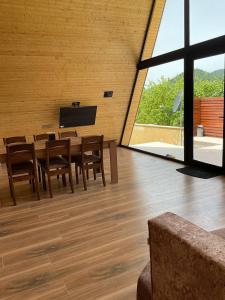 a dining room with a table and chairs and a large window at Aframe Villa Qabala in Gabala