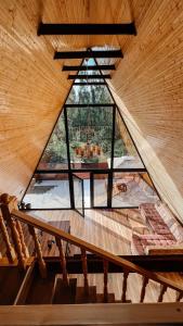 an attic room with a window in a wooden house at Aframe Villa Qabala in Gabala