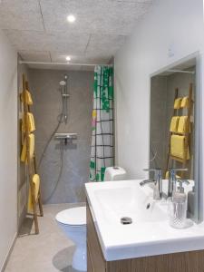a bathroom with a sink and a toilet and a shower at Lejlighed D in Vejle