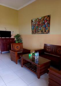 a living room with wooden furniture and a painting on the wall at Hotel Omah Cepit in Cepit
