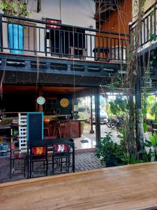 a room with a table and chairs and a balcony at Hotel Omah Cepit in Cepit