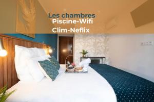 a hotel room with a bed with white sheets and pillows at Maison Le Patio in Saint-Denis