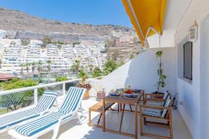 a balcony with chairs and a table with a view at Cliff View Terrace By Dream Homes Tenerife in Puerto de Santiago