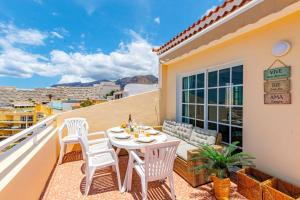 taras ze stołem i krzesłami na balkonie w obiekcie Sunny Arena Sol Apt By Dream Homes Tenerife w mieście Puerto de Santiago