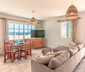 salon z kanapą, stołem i telewizorem w obiekcie Sunny Arena Sol Apt By Dream Homes Tenerife w mieście Puerto de Santiago