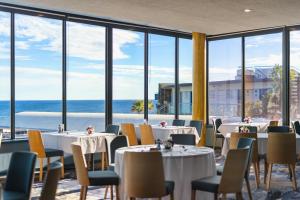 Un restaurante con mesas y sillas y vista al mar. en Mantra Bunbury, en Bunbury