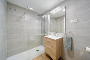 un bagno con un lavandino, uno specchio e una vasca di Soho Malaga by Lovely Home a Málaga Altre 7 foto