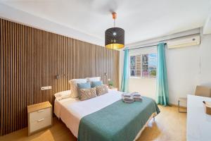 una camera da letto con un letto e una grande finestra di Soho Malaga by Lovely Home a Málaga