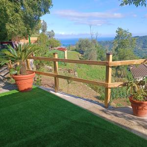 a wooden fence in a yard with green grass at La sosta al bagolaro in Rapallo